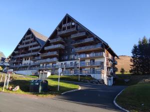 a large apartment building with a road in front at Appartement Super Besse - 6 pers, Piscine, Parking, Balcon - FR-1-814-168 in Vassivière