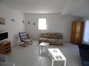 a living room with a couch and a table at Maison proche plage et centre de La Faute-sur-Mer - FR-1-194-314 in La Faute-sur-Mer