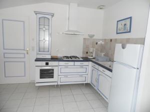 a kitchen with white cabinets and a white refrigerator at Maison proche plage et centre de La Faute-sur-Mer - FR-1-194-314 in La Faute-sur-Mer +4 photos