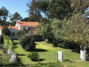 a house with a white fence in the yard at Maison familiale avec jardin, à 1km de la plage - FR-1-194-308 in La Faute-sur-Mer
