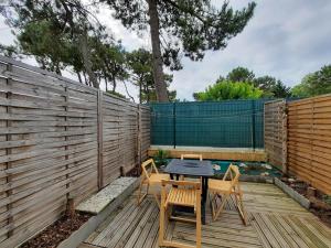 a patio with a table and chairs and a fence at Maisonnette rénovée proche plage avec animaux acceptés et parking - FR-1-194-319 in La Faute-sur-Mer