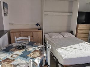 a bedroom with a bed and a table and chairs at Studio à La Faute-sur-Mer avec vue sur la lagune et océan, parking et animal admis - FR-1-194-325 in La Faute-sur-Mer