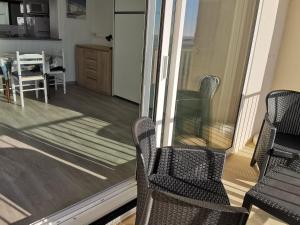 a balcony with two chairs and a table with a kitchen at Studio à La Faute-sur-Mer avec vue sur la lagune et océan, parking et animal admis - FR-1-194-325 in La Faute-sur-Mer