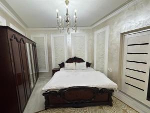 a bedroom with a bed and a chandelier at Apartment Nabi Bobo in Samarkand