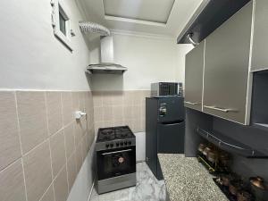 a small kitchen with a stove and a refrigerator at Apartment Nabi Bobo in Samarkand