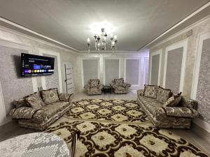 a living room with two couches and a tv at Apartment Nabi Bobo in Samarkand
