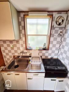 a small kitchen with a sink and a window at ist villa 03 Seaside Cabin Sleeps 5 in Bizen
