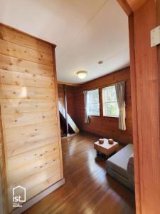 a room with wooden walls and a couch and a table at Simple Island Villa Surrounded by Nature Peaceful Stay in Bizen