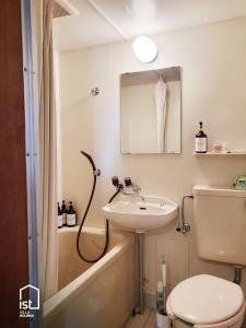 a bathroom with a sink and a toilet and a bath tub at ist villa 03 Seaside Cabin Sleeps 5 in Bizen
