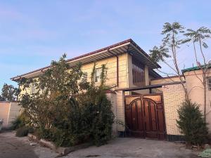 a house with a large wooden garage door at Apartment Nabi Bobo in Samarkand