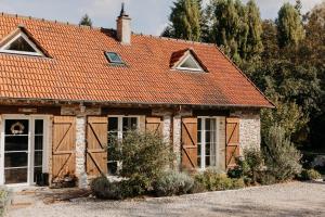 an old house with an orange roof at Domaine des Pousses, Chambres d'hôtes au coeur d'un village de campagne in Droue-sur-Drouette
