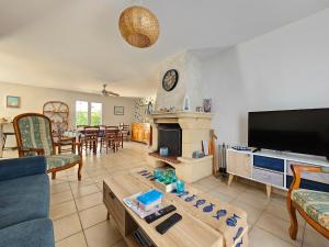 a living room with a couch and a tv at Maison spacieuse avec jardin, animaux admis - FR-1-476-250 in La Faute-sur-Mer