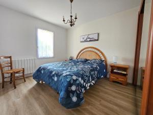 a bedroom with a bed with a blue blanket at Maison spacieuse avec jardin, animaux admis - FR-1-476-250 in La Faute-sur-Mer +6 photos