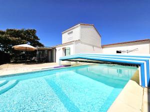 a swimming pool in front of a house at Maison spacieuse avec jardin, animaux admis - FR-1-476-250 in La Faute-sur-Mer