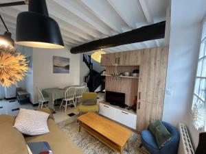 un soggiorno con un divano e un tavolo di Maison de pêcheur cosy à Sarzeau pour 5 pers. avec jardin privé et parking. - FR-1-639-155 a Brillac