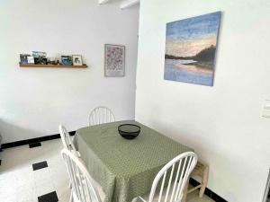 una sala da pranzo con tavolo verde e sedie bianche di Maison de pêcheur cosy à Sarzeau pour 5 pers. avec jardin privé et parking. - FR-1-639-155 a Brillac