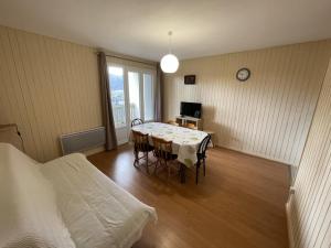 勒利然Spacieux T2 avec balcon près des pistes au Lioran - FR-1-787-134的客房设有桌子、床和桌椅。