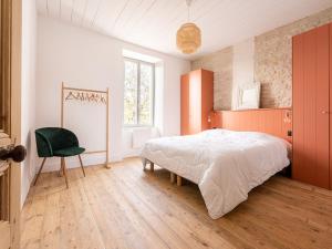 a bedroom with a large bed and a green chair at Maison de charme à La Flotte, 6 personnes, rénovée avec terrasse - FR-1-835-35 in La Flotte