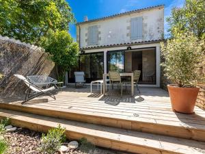 a wooden deck with a table and chairs on it at Maison de charme à La Flotte, 6 personnes, rénovée avec terrasse - FR-1-835-35 in La Flotte