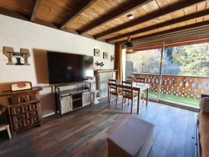 a living room with a dining table and a television at Studio coin montagne avec balcon - Pra Loup 1600 - FR-1-804-57 in Pra-Loup