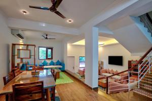 a living room with a dining table and a couch at Private Pool 3BHK Villa near Candolim in Goa