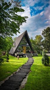 a small building with a roof on a grass field at Porumbacu Garden in Porumbacu de Sus
