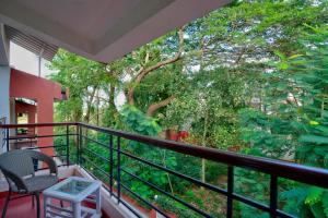 a balcony with a table and a chair and trees at Private Pool 3BHK Villa near Candolim in Goa