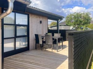 a patio with chairs and a table on a deck at Renovated Beach House - By Traum Ferienwohnungen in Juelsminde