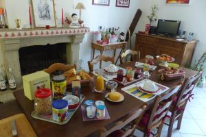 mesa de comedor con desayuno y chimenea en Chambre D'hôtes De Bellevue, en Lanvallay
