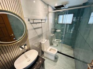 um banheiro com vaso sanitário e box de vidro em Munnar Peak Paradise em Devikolam mais 11 fotografias