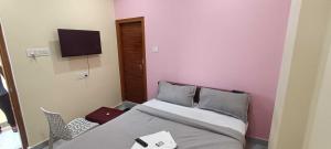 a small bedroom with a bed and a tv at Hotel O Laxmi Grand in Dhundgol