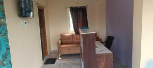 a room with a chair and a desk and a television at Hotel O Laxmi Grand in Dhundgol