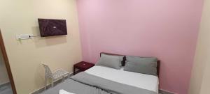 a bedroom with a bed and a tv on the wall at Hotel O Laxmi Grand in Dhundgol