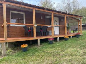 a log cabin with chairs and a porch at Hetedhét Csillag Apartmanház in Bábonymegyer