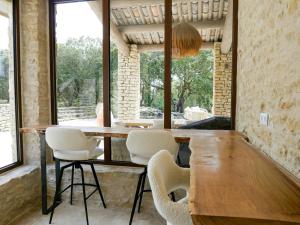 a dining room with a wooden table and white chairs at Stunning Stone House With Pool Near Gordes in Gordes
