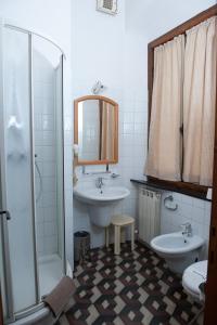 ein Bad mit einem Waschbecken, einem WC und einer Dusche in der Unterkunft Albergo Vittoria in Busalla