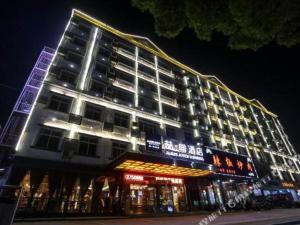 een groot gebouw met 's nachts verlichting bij James Joyce Coffetel Nanchang West Station Nanchang University in Xinjian