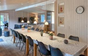 a large dining room with a long table and chairs at Awesome Home In Væggerløse With Sauna in Marielyst