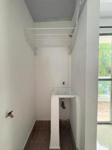 a white bathroom with a sink and a window at Maru apartamentos in Cartagena de Indias