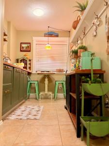 a kitchen with green cabinets and a table and chairs at A Room of One's Own-A perfect getaway by the sea in North Nanaimo in Nanaimo