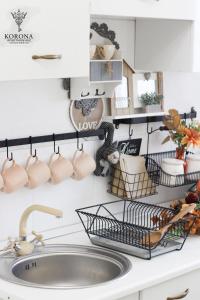 a kitchen counter with a sink and mugs on the wall at Korona Apartman Székesfehérvár in Székesfehérvár