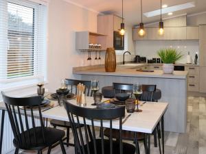 a dining room with a table and chairs in a kitchen at 38 At The Sanctuary Lodges - Uk50850 in Carnguwch