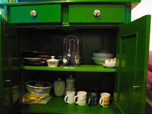 a green cabinet with cups and dishes in it at Room Galina in Duga Resa