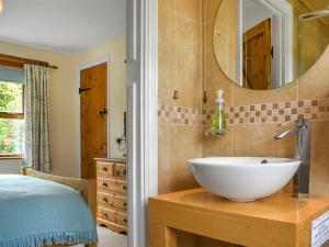 a bathroom with a sink and a mirror at Lower Axford Cottage in Callington