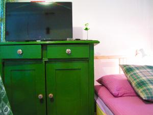 a green dresser with a tv on top of it at Room Galina in Duga Resa