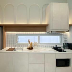 a kitchen with white cabinets and a sink at The Pool Space - ICONIC Pool Villa in Ban Huai Yai
