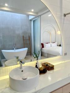 a bathroom with a white sink and a mirror at The Pool Space - ICONIC Pool Villa in Ban Huai Yai