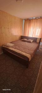 ein Bett in einem Zimmer mit einer Holzwand in der Unterkunft Zebra Guest House in Ulaanbaatar