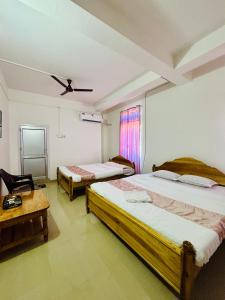 a bedroom with two beds and a table at Victus Emporium in Guwahati