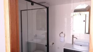 ein Badezimmer mit Glasdusche und Waschbecken in der Unterkunft Bay and Bush Jervis Bay - Nature Retreat in Huskisson + 48 Fotos
